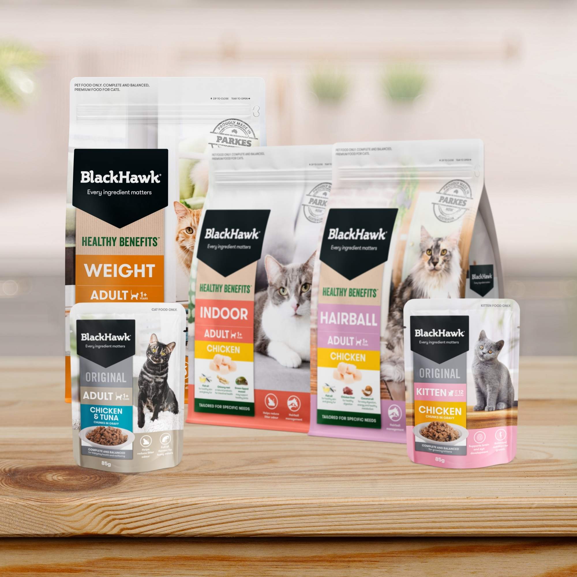 Black Hawk dry and wet cat food packaging on a wooden kitchen benchtop.
