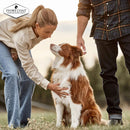 A lady and a man with a dog outdoors with Ivory Coat branding promoting adult dog food