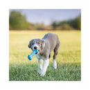 A grey and white puppy running on a grassy field while holding a bright blue KONG Puppy Goodie Bone dog toy in its mouth, with a blurred outdoor background.