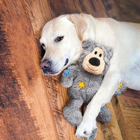 Golden Labrador cuddling a Grey KONG Wild Knots Bear - dog toy.