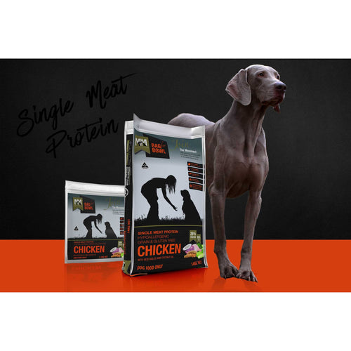 Meals for Mutts Single Meat Protein Chicken dry dog food bags beside a relaxed dog