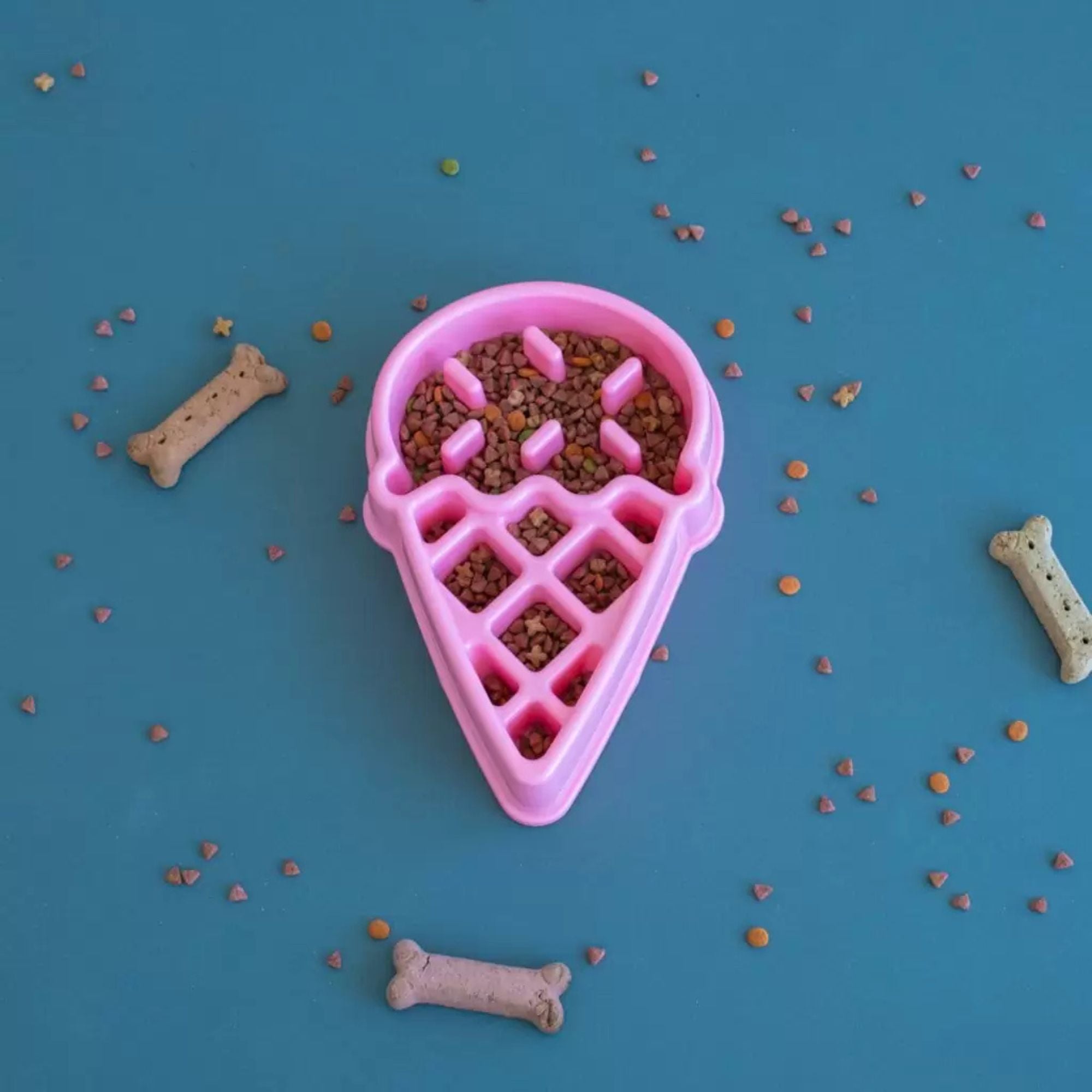 ZippyPaws Happy Bowl Ice Cream slow feed dog bowl filled with kibble, styled flat lay with dog treats