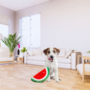 Puppy sitting beside the ZippyPaws NomNomz Watermelon plush dog toy on a living room floor